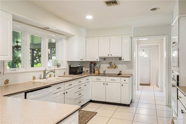 kitchen with white cabinetry, sink, tasteful backsplash, light tile patterned floors, and white appliances