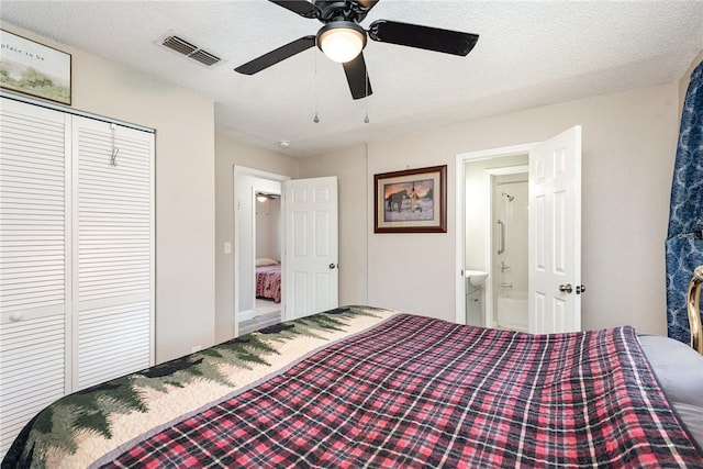 bedroom with a textured ceiling, ceiling fan, a closet, and visible vents