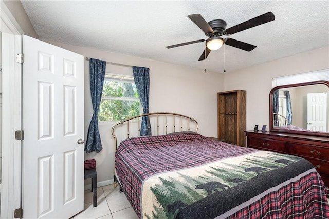 bedroom with tile patterned flooring, ceiling fan, and a textured ceiling