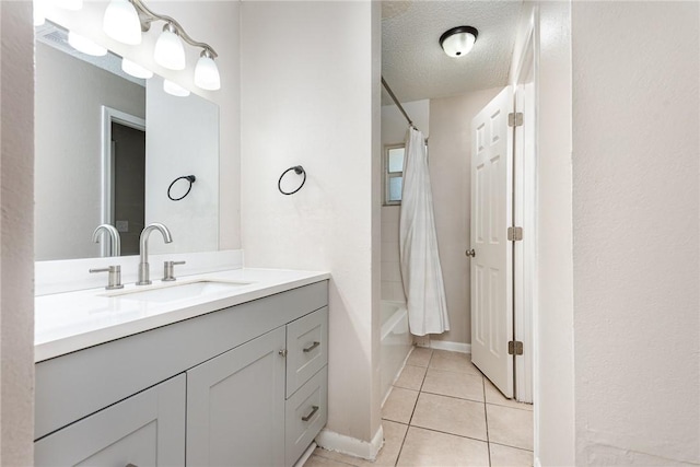 full bathroom with a textured ceiling, shower / bath combination with curtain, vanity, and tile patterned floors