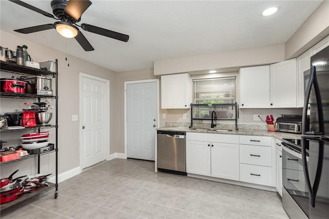 kitchen with freestanding refrigerator, white cabinets, a sink, and stainless steel dishwasher