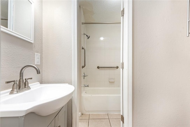 bathroom with a textured wall, tile patterned flooring, a textured ceiling, vanity, and shower / bathing tub combination