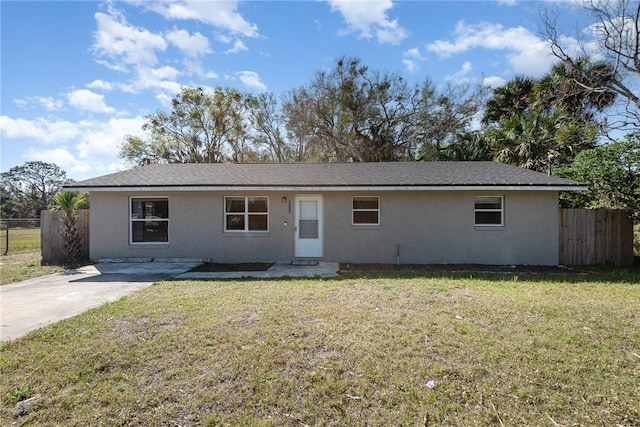 ranch-style home with a front yard, fence, and stucco siding