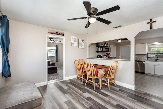 dining area featuring dark wood-style floors, visible vents, and baseboards