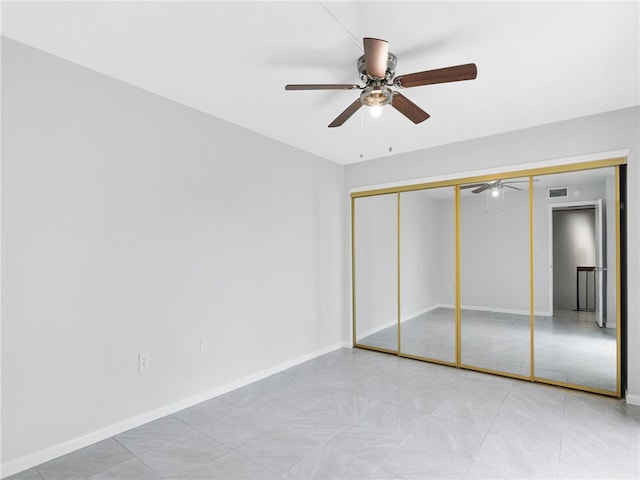 unfurnished bedroom with ceiling fan and a closet