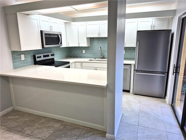 kitchen featuring white cabinets, sink, stainless steel appliances, and tasteful backsplash