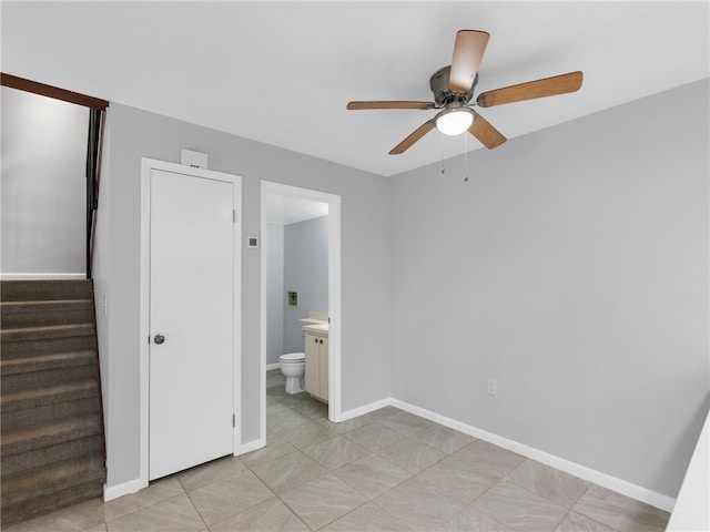 unfurnished bedroom with ensuite bathroom, ceiling fan, and light tile patterned floors