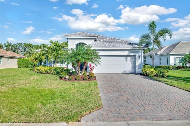 mediterranean / spanish home with a garage, a front lawn, decorative driveway, and stucco siding