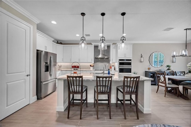 kitchen with a breakfast bar area, stainless steel appliances, visible vents, wall chimney range hood, and backsplash