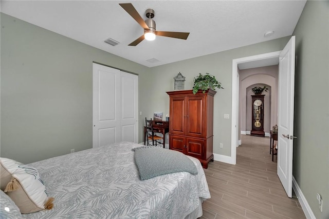 bedroom featuring baseboards, visible vents, ceiling fan, wood tiled floor, and a closet