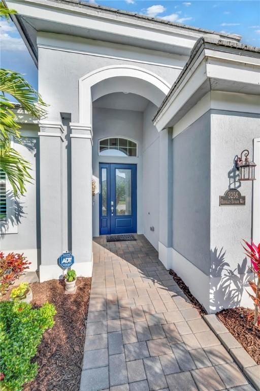 property entrance with french doors and stucco siding