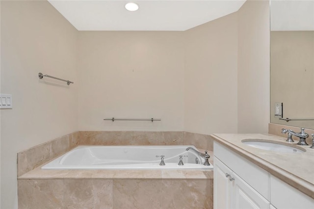 bathroom featuring tiled bath and vanity