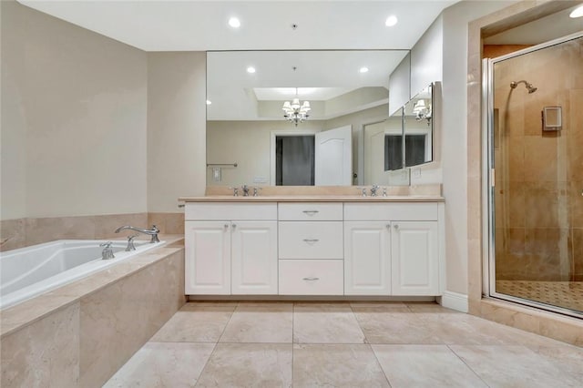 bathroom with tile patterned floors, a notable chandelier, separate shower and tub, and vanity