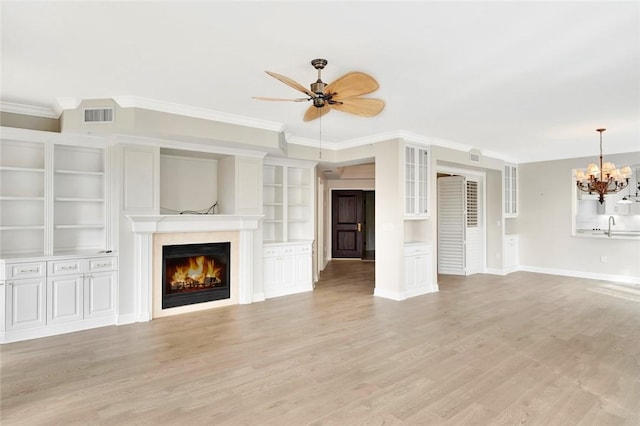 unfurnished living room featuring sink, built in features, crown molding, light hardwood / wood-style floors, and ceiling fan with notable chandelier