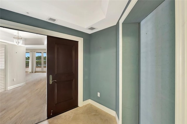 foyer featuring light hardwood / wood-style flooring and a tray ceiling