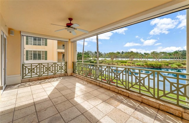 balcony with ceiling fan and a water view