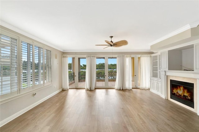 unfurnished living room with ceiling fan, light hardwood / wood-style floors, ornamental molding, and french doors