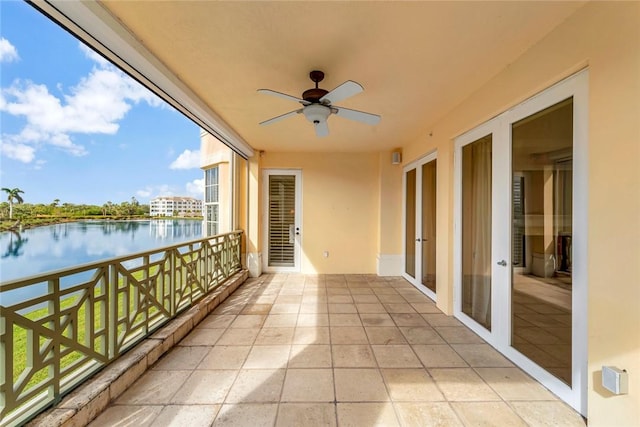 balcony with ceiling fan and a water view