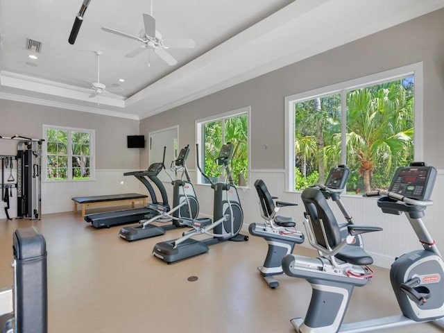 exercise room featuring a wealth of natural light, visible vents, a wainscoted wall, and ceiling fan