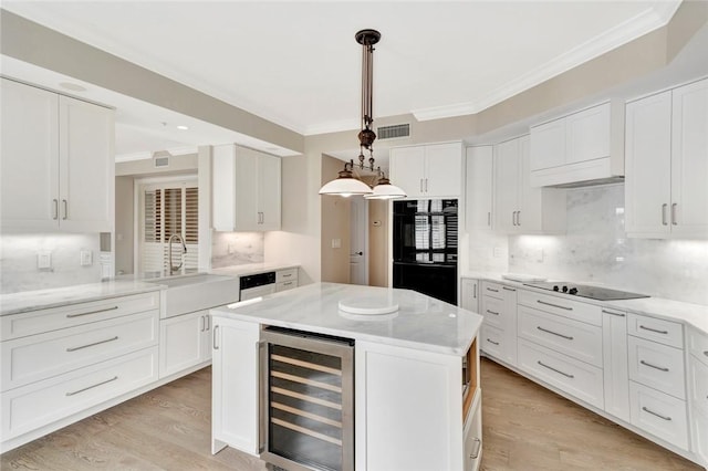 kitchen with black appliances, pendant lighting, white cabinets, and beverage cooler