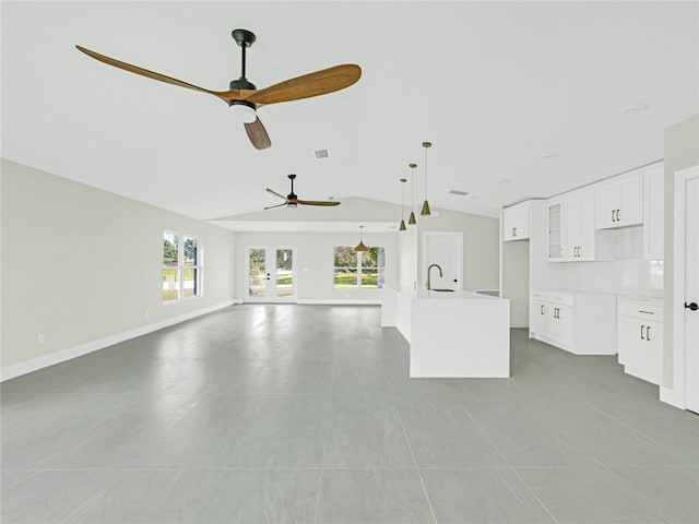 unfurnished living room with light tile patterned flooring, ceiling fan, lofted ceiling, and sink