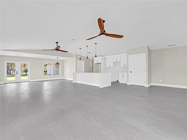 unfurnished living room with french doors, light tile patterned floors, and vaulted ceiling