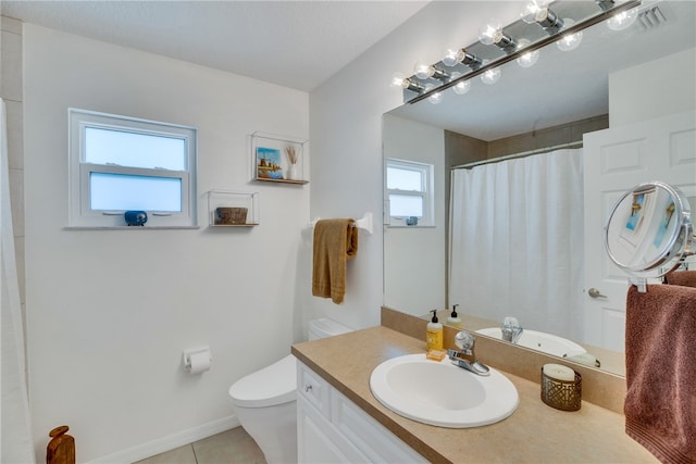 bathroom featuring toilet, vanity, a healthy amount of sunlight, and tile patterned floors