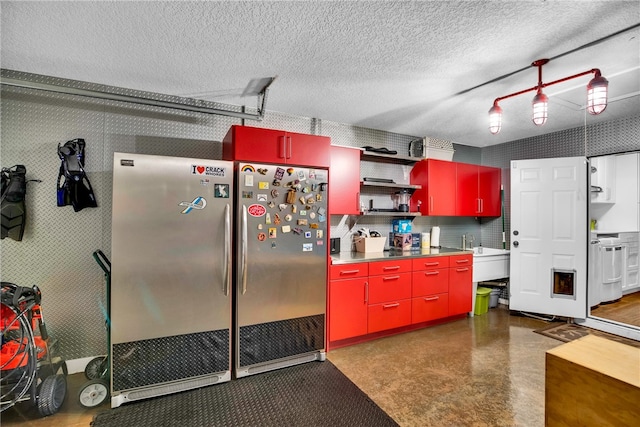 kitchen with sink, a textured ceiling, and stainless steel fridge