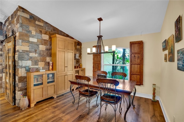 dining area featuring an inviting chandelier, lofted ceiling, and wood-type flooring