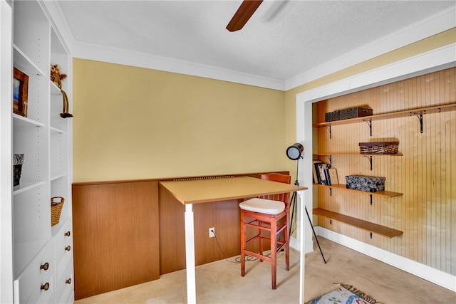 office featuring wood walls, ceiling fan, a textured ceiling, and ornamental molding