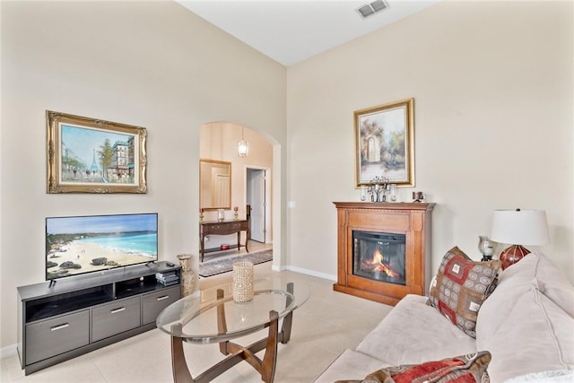 5744 Cahaba St, Port St Lucie, FL 34986 - living room with a glass covered fireplace, arched walkways, and light tile patterned flooring