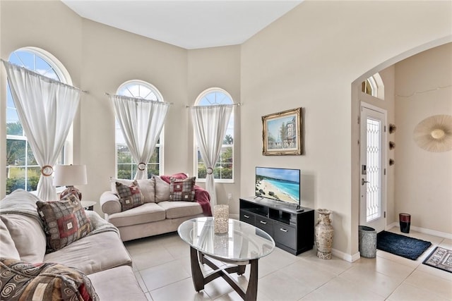 5744 Cahaba St, Port St Lucie, FL 34986 - living area featuring arched walkways, light tile patterned flooring, and a towering ceiling