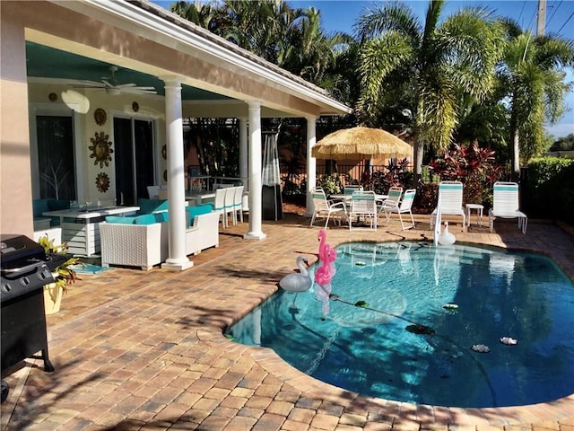 view of swimming pool featuring outdoor lounge area, ceiling fan, a patio, and grilling area