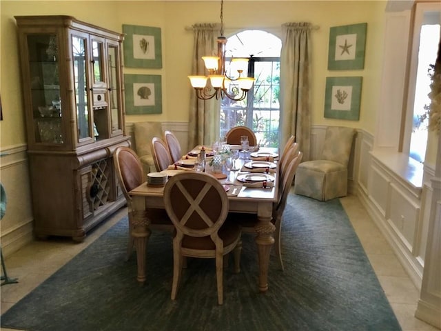 dining space with tile patterned flooring and a chandelier