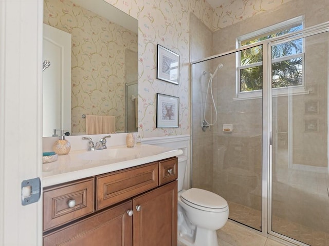 bathroom with tile patterned floors, a shower with door, vanity, and toilet