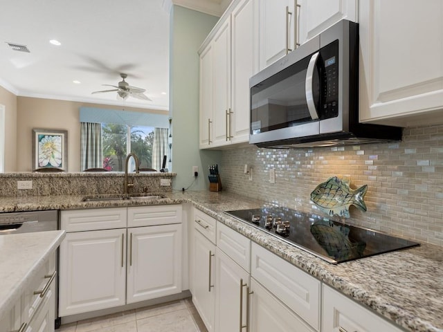 kitchen featuring white cabinetry, sink, tasteful backsplash, crown molding, and appliances with stainless steel finishes