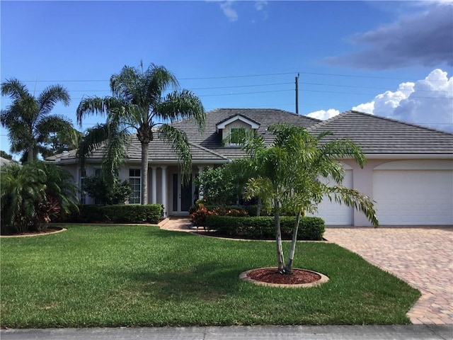 single story home with a garage and a front lawn