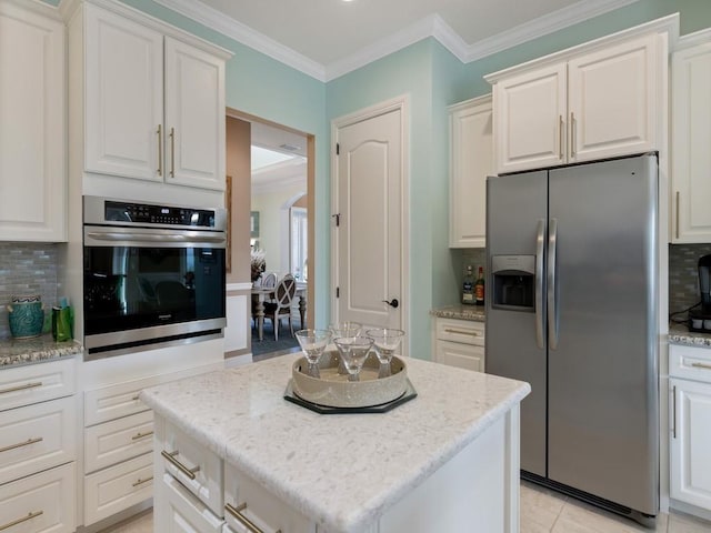 kitchen with backsplash, white cabinetry, a center island, and stainless steel appliances