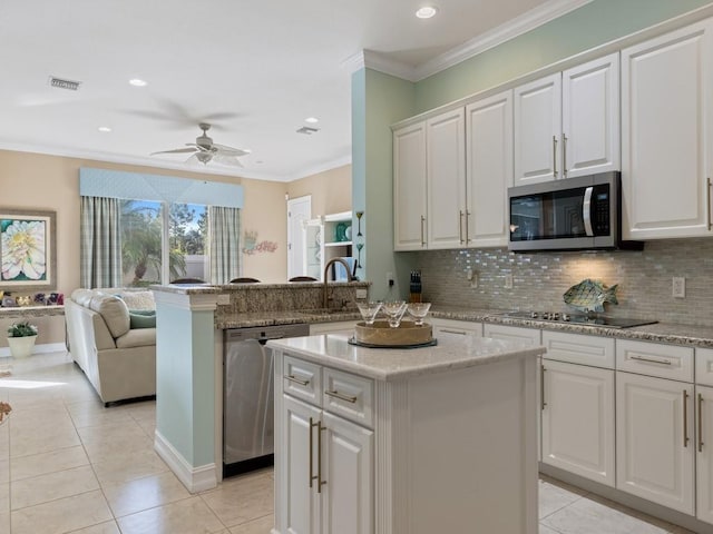 kitchen with kitchen peninsula, stainless steel appliances, light tile patterned floors, white cabinets, and a kitchen island