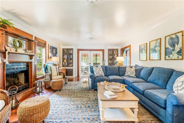 6160 1st St SW, Vero Beach, FL 32968 - living area featuring plenty of natural light, wood finished floors, a fireplace, french doors, and ornamental molding