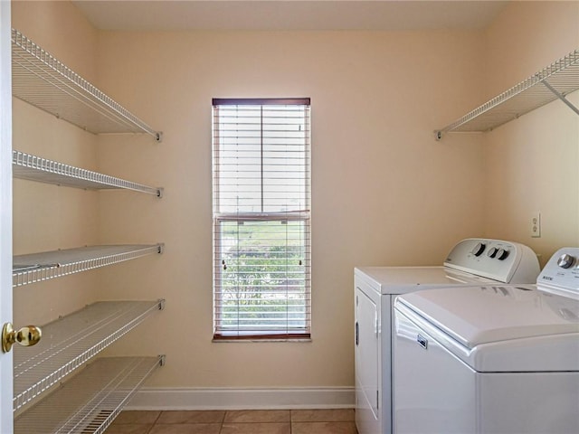 washroom with washer and clothes dryer and light tile patterned floors