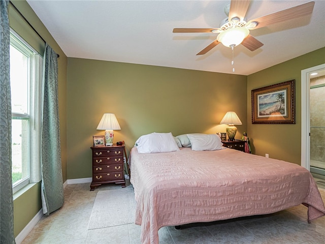 bedroom with multiple windows, ceiling fan, and light tile patterned floors