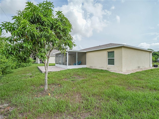 rear view of property featuring a sunroom and a lawn