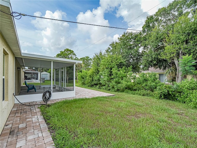 view of yard featuring a patio area and a sunroom