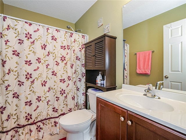 bathroom with toilet, vanity, a textured ceiling, and walk in shower