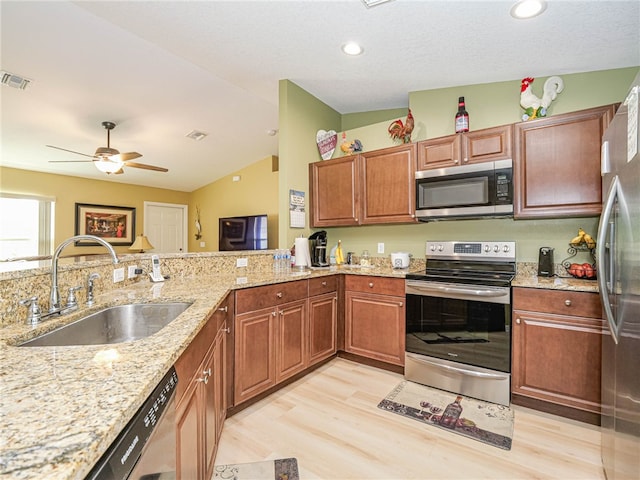 kitchen with stainless steel appliances, sink, light stone counters, light hardwood / wood-style flooring, and lofted ceiling