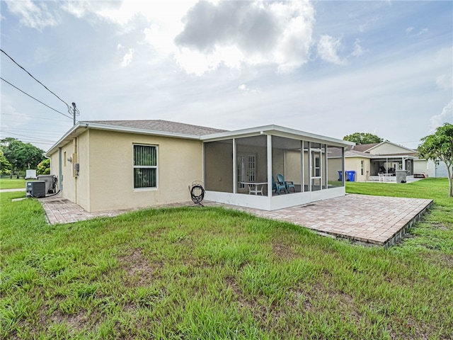 rear view of property with a patio area, a sunroom, and a yard