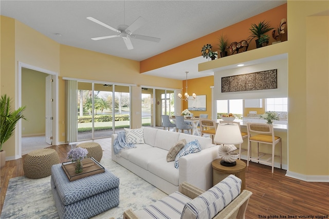 living room with wood-type flooring, plenty of natural light, and ceiling fan with notable chandelier