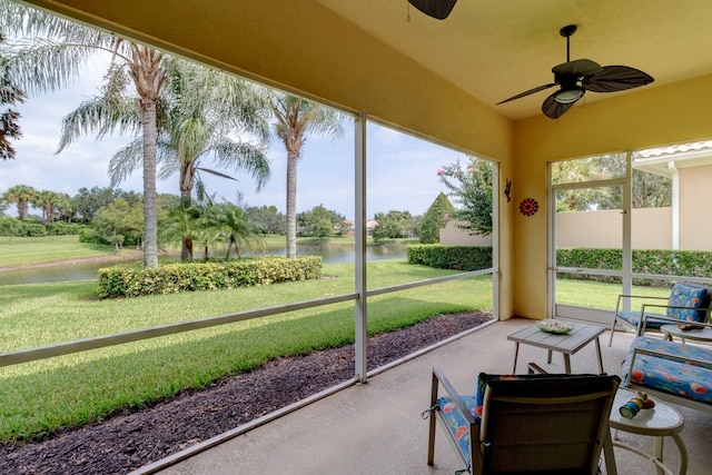 sunroom featuring a water view and ceiling fan