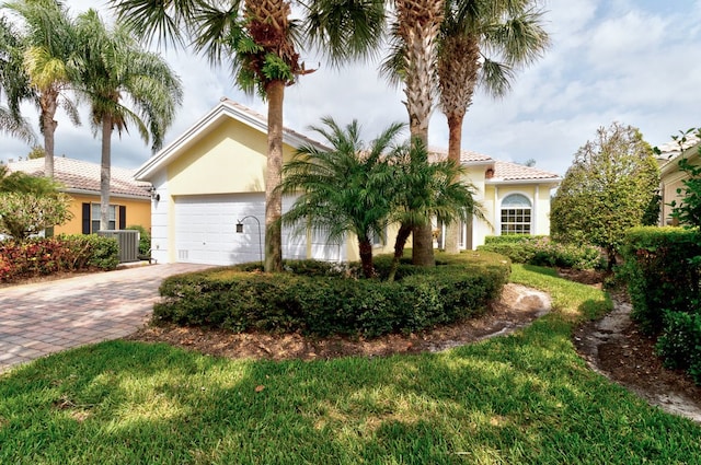 view of front of house featuring a garage, central AC, and a front yard